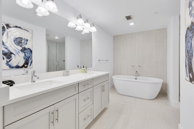 bathroom featuring a sink, visible vents, a soaking tub, a shower stall, and double vanity