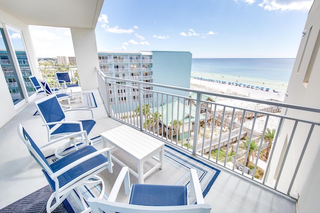 balcony with a water view and a view of the beach