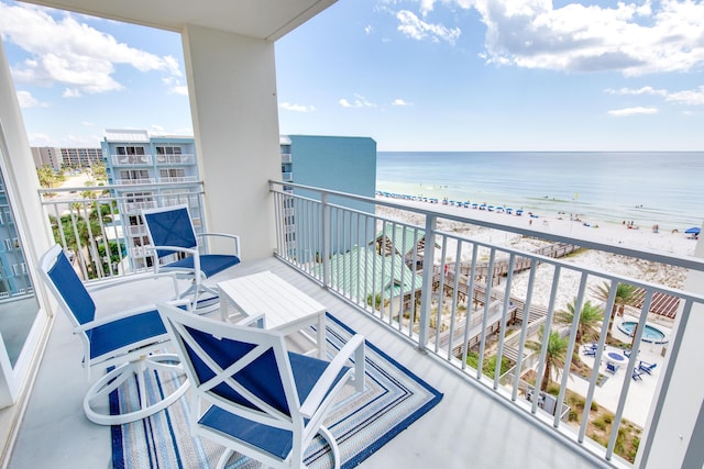 balcony featuring a beach view and a water view