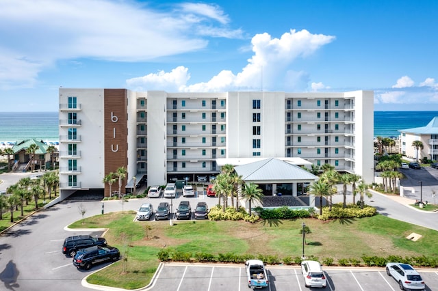 view of building exterior with a water view and uncovered parking