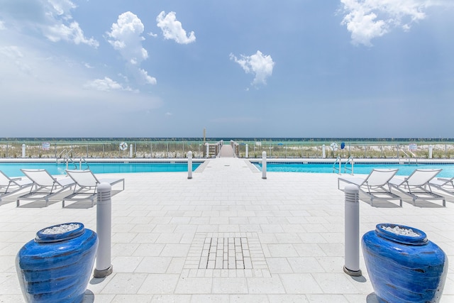 view of pool with a water view and fence