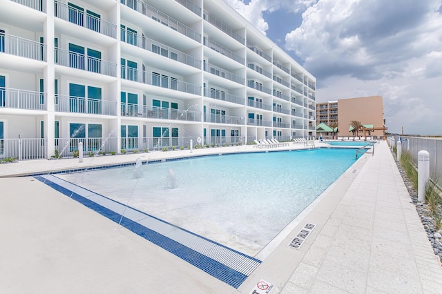 pool with a patio area and fence