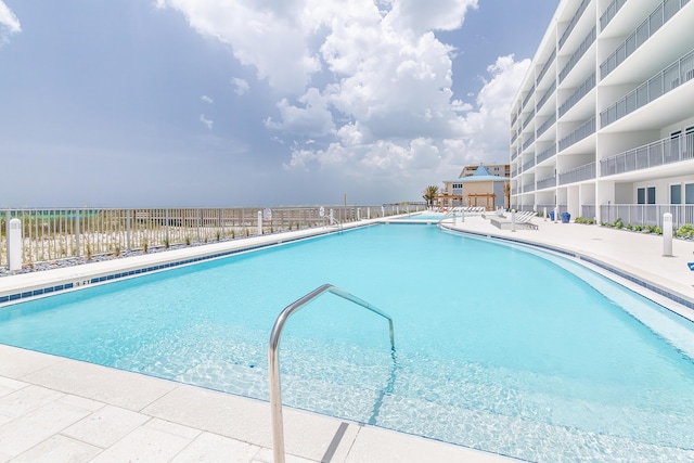 community pool with fence and a patio