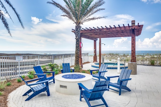 view of patio featuring a fire pit, a water view, fence, and a pergola