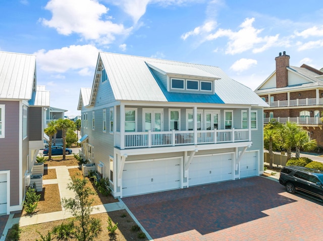 view of front of house with driveway, an attached garage, metal roof, and central AC