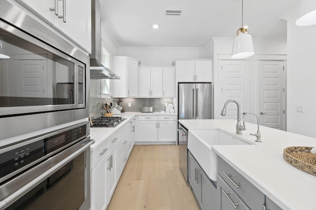 kitchen with appliances with stainless steel finishes, light countertops, backsplash, and ornamental molding