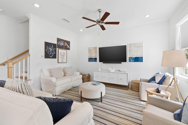 living area with ornamental molding, recessed lighting, visible vents, and stairs