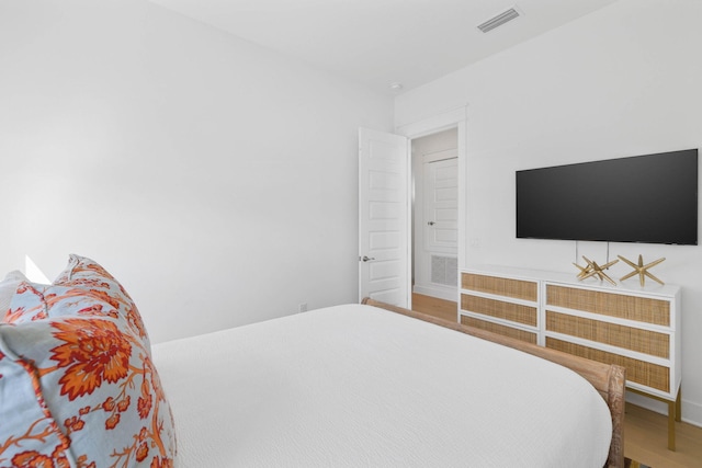 bedroom featuring visible vents and wood finished floors