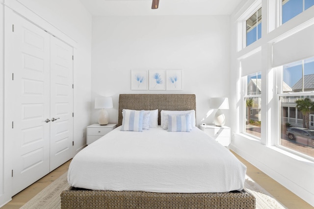 bedroom with a ceiling fan, a closet, baseboards, and wood finished floors