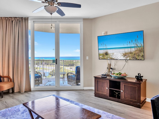 interior space with a ceiling fan, wood finished floors, and baseboards