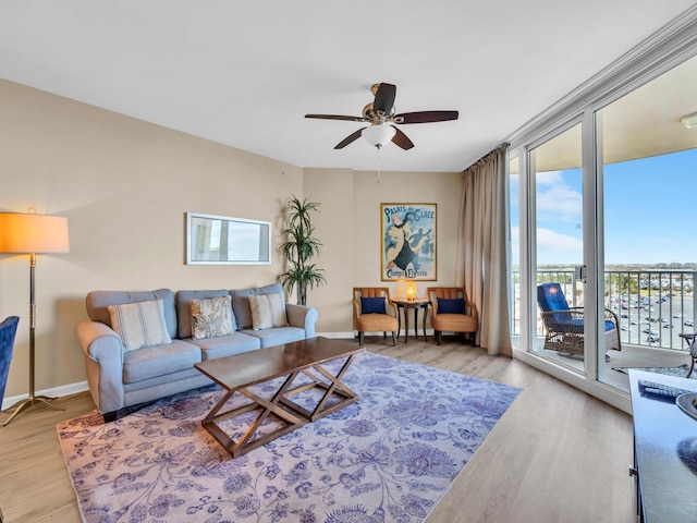 living area with floor to ceiling windows, wood finished floors, and baseboards