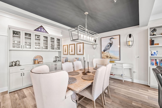 dining area with baseboards, light wood-type flooring, and a notable chandelier