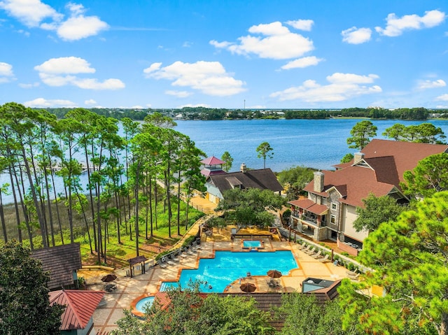 community pool with a water view and a patio area