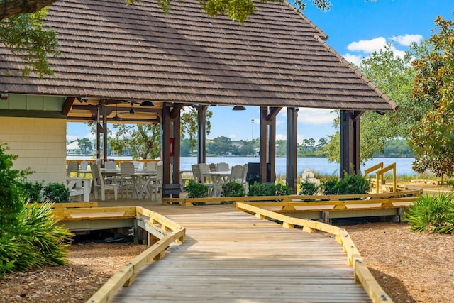 view of dock with a water view and outdoor dining area