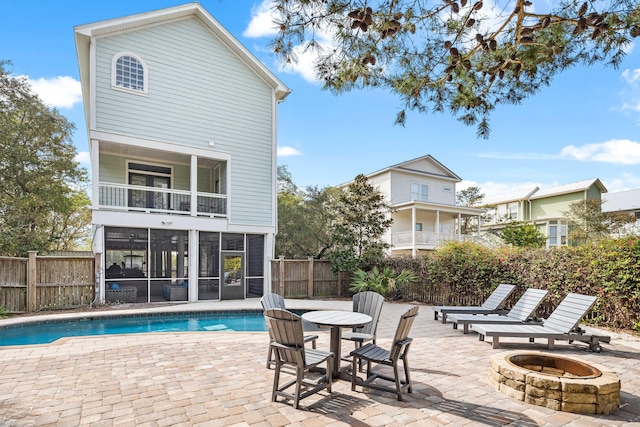 view of pool with a fenced in pool, an outdoor fire pit, a sunroom, and fence private yard