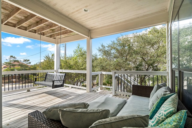 wooden terrace with an outdoor living space