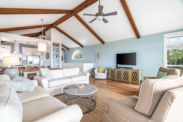 living room featuring high vaulted ceiling, a ceiling fan, beam ceiling, and light wood-style floors