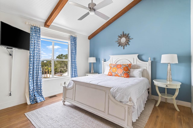 bedroom with lofted ceiling with beams, light wood-type flooring, visible vents, and baseboards