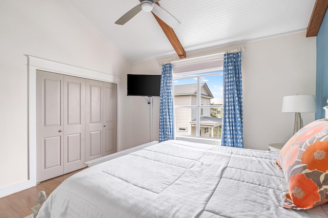 bedroom with a closet, ceiling fan, lofted ceiling with beams, and wood finished floors