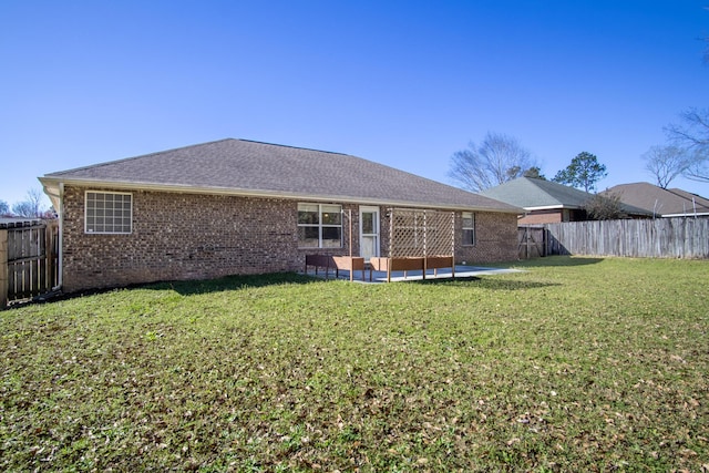 3098 Border Creek Dr, Crestview, FL 32539 - back of property with a shingled roof, a patio, a fenced backyard, a yard, and brick siding
