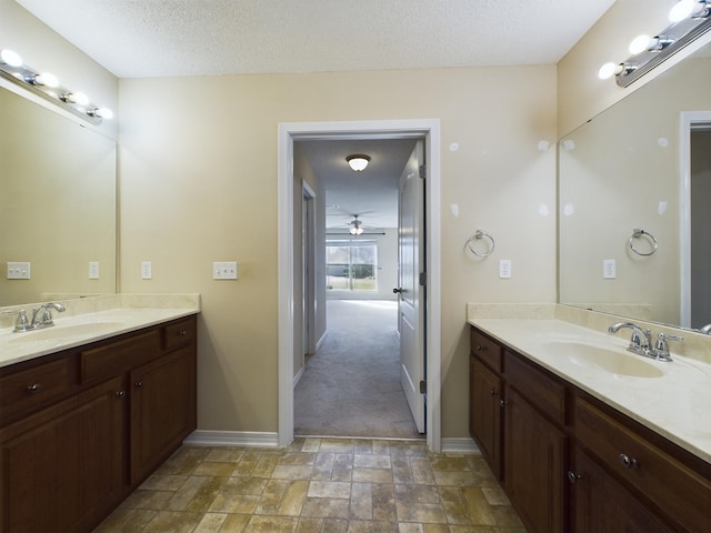 3098 Border Creek Dr, Crestview, FL 32539 - bathroom featuring a textured ceiling, stone finish floor, a sink, and baseboards