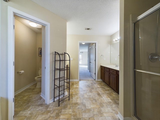 3098 Border Creek Dr, Crestview, FL 32539 - bathroom with visible vents, toilet, stone finish floor, a textured ceiling, and vanity