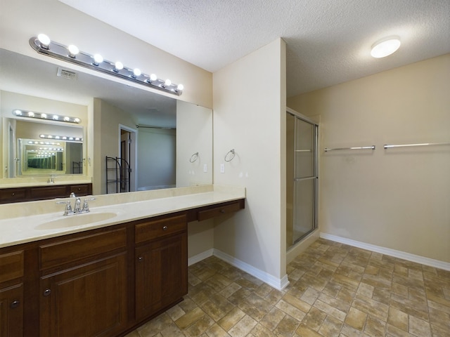 3098 Border Creek Dr, Crestview, FL 32539 - full bath with visible vents, vanity, a shower stall, a textured ceiling, and baseboards