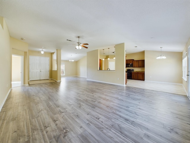 3098 Border Creek Dr, Crestview, FL 32539 - unfurnished living room featuring light wood-style floors, lofted ceiling, baseboards, and ceiling fan with notable chandelier