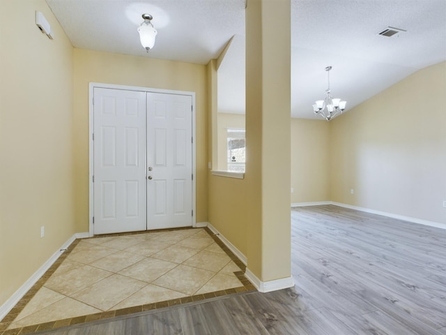 3098 Border Creek Dr, Crestview, FL 32539 - foyer entrance with lofted ceiling, a notable chandelier, wood finished floors, visible vents, and baseboards
