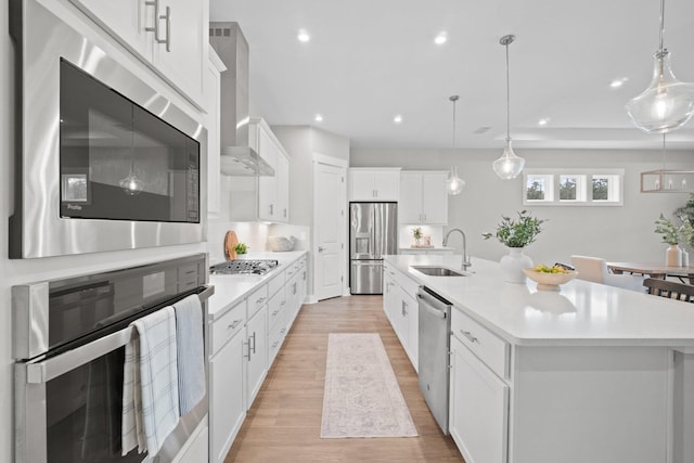 kitchen with stainless steel appliances, a spacious island, a sink, white cabinets, and light countertops