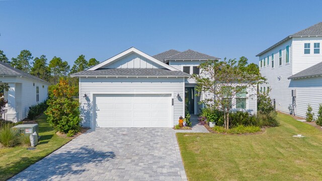 view of front of home with a garage, decorative driveway, board and batten siding, and a front yard