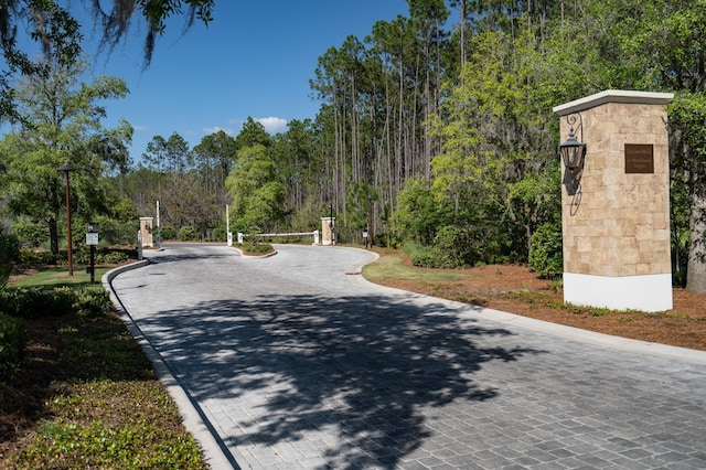 surrounding community featuring decorative driveway