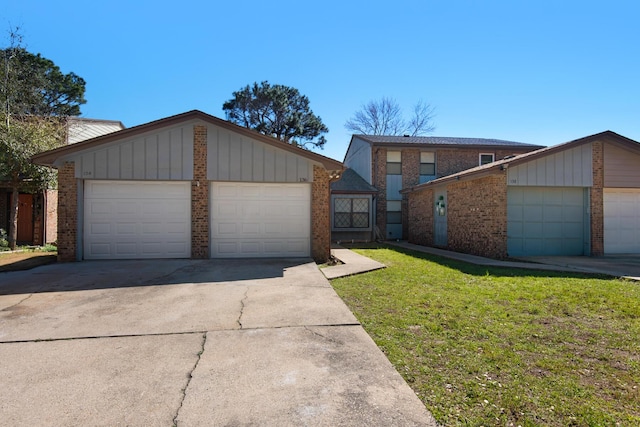 mid-century home featuring a garage, an outdoor structure, a front lawn, board and batten siding, and brick siding