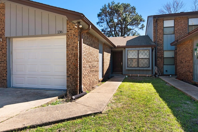 view of front of property with a garage, brick siding, board and batten siding, and a front lawn