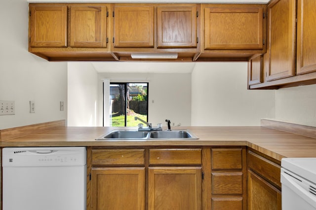 kitchen featuring light countertops, brown cabinetry, a sink, dishwasher, and a peninsula