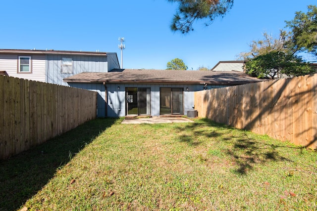 back of property featuring a yard and a fenced backyard