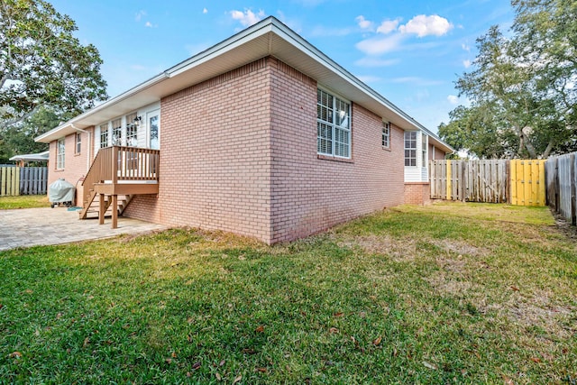 view of home's exterior featuring a patio area, a fenced backyard, a lawn, and brick siding