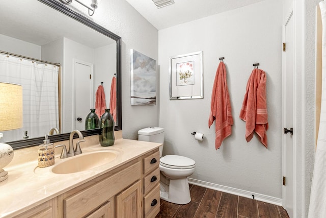 bathroom featuring toilet, vanity, wood finished floors, a shower with curtain, and baseboards