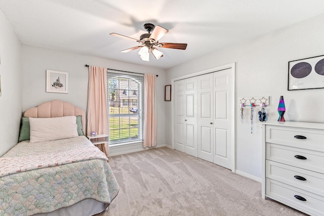 bedroom featuring light carpet, a closet, a ceiling fan, and baseboards