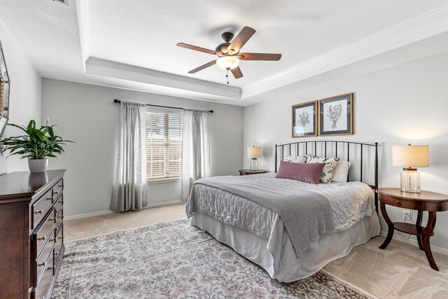 bedroom featuring baseboards, a tray ceiling, and light colored carpet