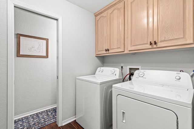 clothes washing area featuring cabinet space, baseboards, dark wood finished floors, a textured wall, and washer and dryer