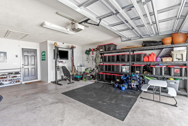 garage featuring a sink, electric panel, and a garage door opener