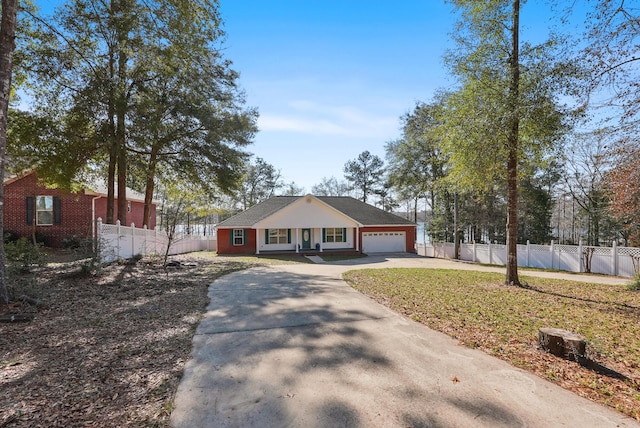 view of front of property with an attached garage, fence private yard, driveway, and a front yard