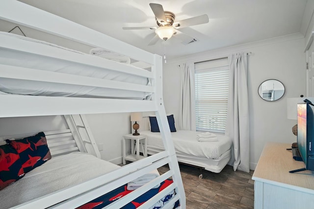 bedroom featuring visible vents, baseboards, dark wood-style floors, ceiling fan, and ornamental molding