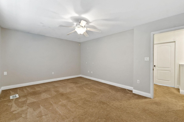 carpeted spare room with baseboards and ceiling fan