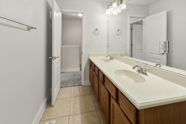 full bath with tile patterned floors, double vanity, baseboards, and a sink