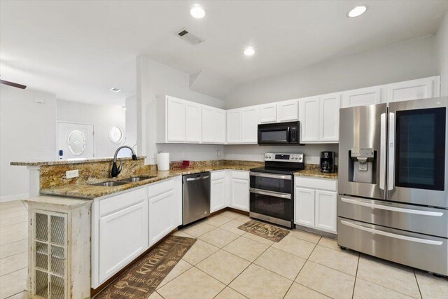 kitchen featuring visible vents, light stone countertops, appliances with stainless steel finishes, a peninsula, and a sink