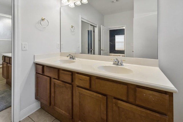 full bath featuring tile patterned flooring, visible vents, double vanity, and a sink