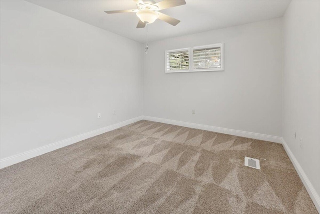 unfurnished room with visible vents, light colored carpet, baseboards, and ceiling fan