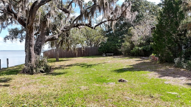 view of yard featuring a water view and fence